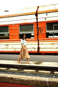 Side view of woman walking at railroad station