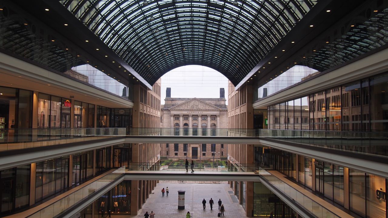 architecture, built structure, indoors, ceiling, modern, railing, glass - material, building exterior, incidental people, window, reflection, building, architectural feature, day, city, arch, shopping mall, architectural column, pattern, travel destinations