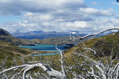 Scenic view of lake by mountains against sky