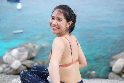 Portrait of young woman standing at beach