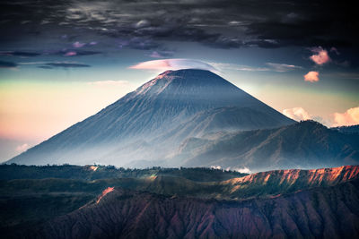 Aerial view of snowcapped mountain against cloudy sky