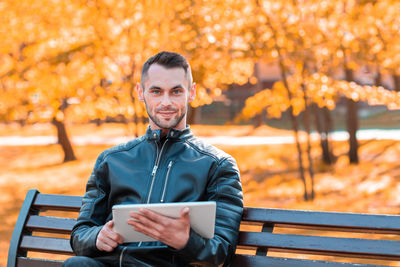 Portrait of young man sitting on bench