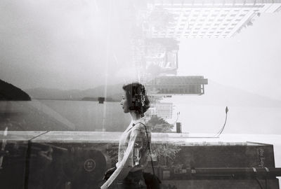 Double exposure of young woman and buildings