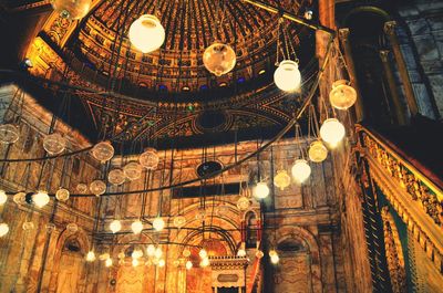 Low angle view of illuminated lamp in temple at night