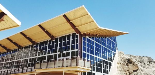 Low angle view of modern building against clear blue sky