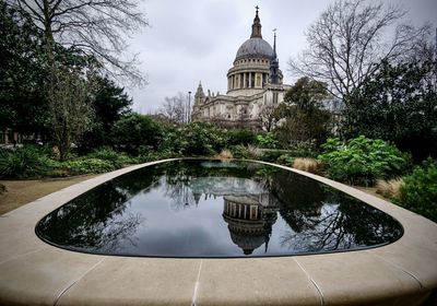 Fountain in park with historic cathedral reflection 