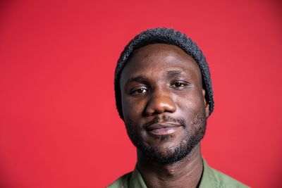 Portrait of young man against red background