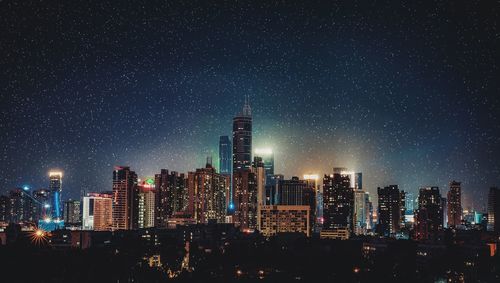 Illuminated buildings against sky at night