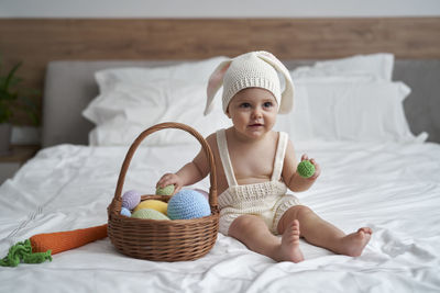 Cute girl sitting on bed at home