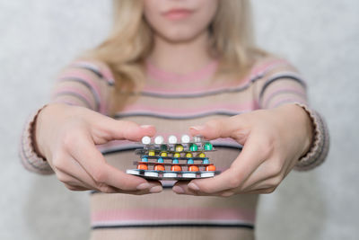 Midsection of woman holding pills