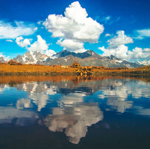 Scenic view of lake by mountains against sky