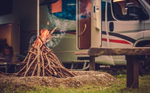 Close-up of burning firewood by car