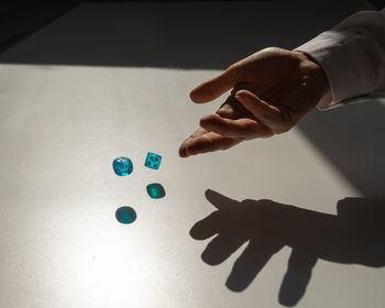 Cropped hand of person holding jigsaw pieces on table