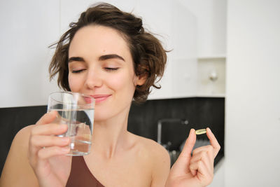 Portrait of smiling young woman using mobile phone