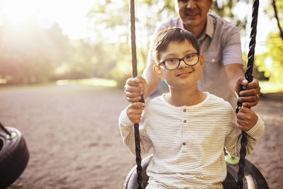 Father swinging disabled son at playground