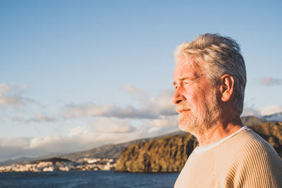 Portrait of man looking at sea against sky