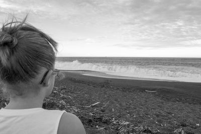 Close-up of young woman on beach against sky