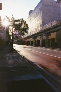 Road by building in city against sky