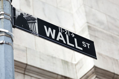 Low angle view of information sign on wall