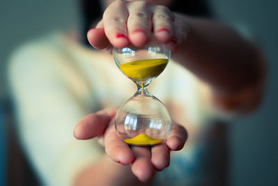 Midsection of woman holding hourglass