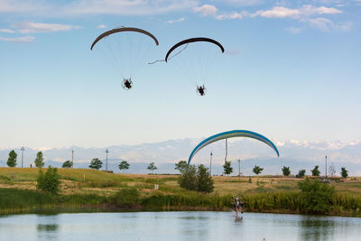 People paragliding over river