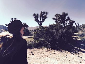 Rear view of woman at desert with joshua trees in background