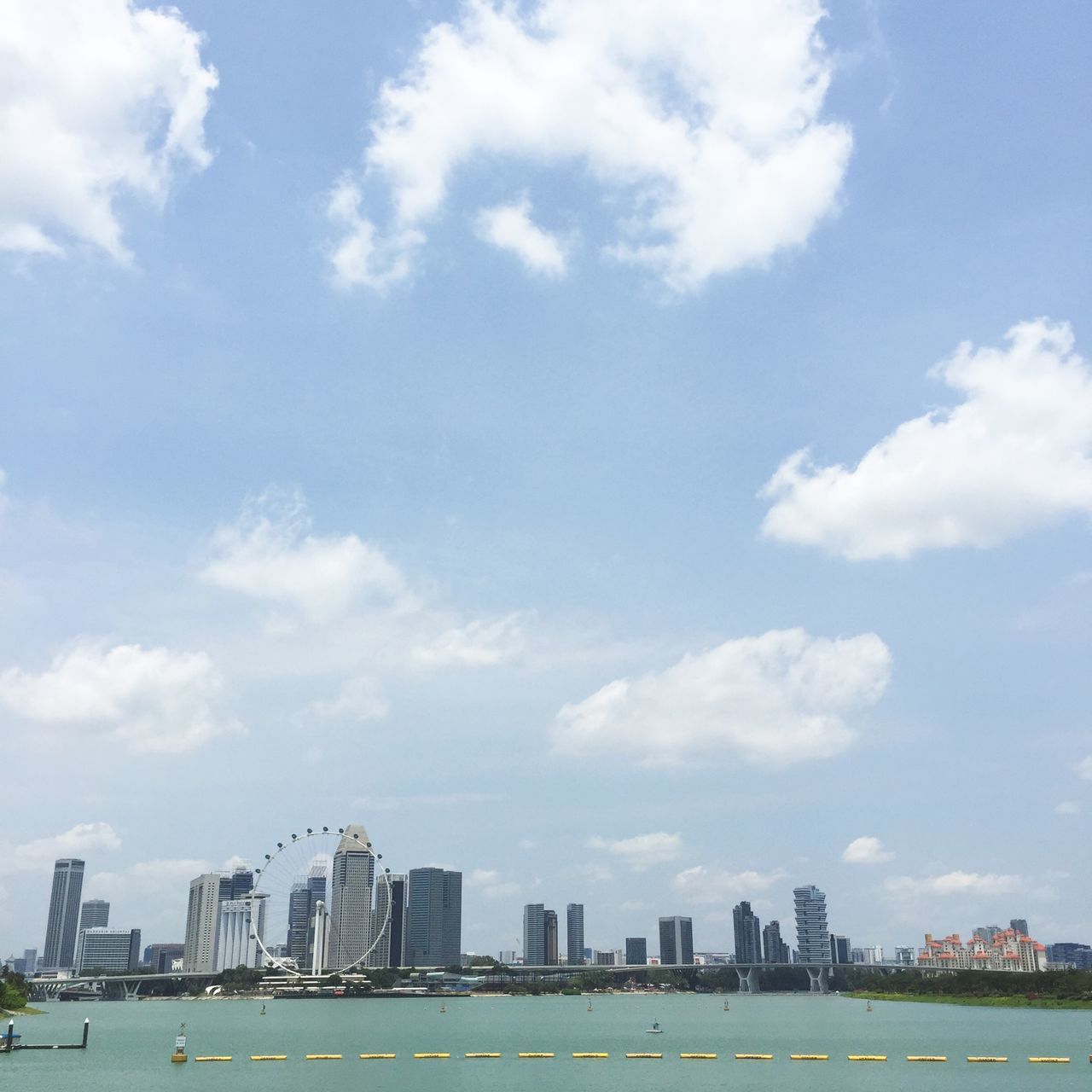 building exterior, architecture, sky, built structure, city, cloud - sky, cityscape, cloud, skyscraper, water, cloudy, urban skyline, day, blue, skyline, tall - high, tower, river, city life, outdoors