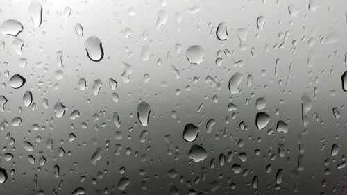 Full frame shot of raindrops on glass window