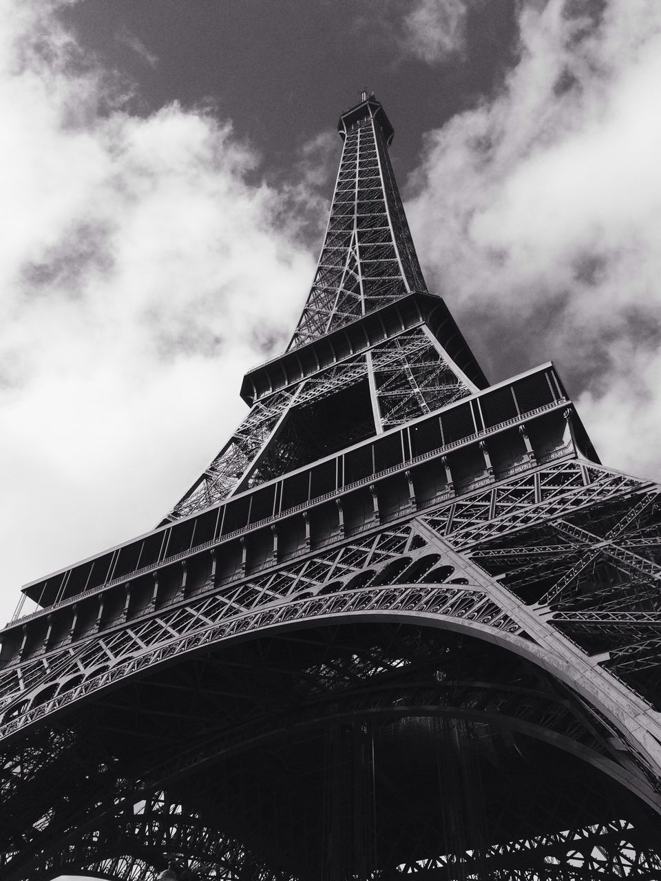 famous place, eiffel tower, architecture, international landmark, travel destinations, built structure, tourism, capital cities, low angle view, tower, travel, culture, tall - high, sky, architectural feature, city, history, metal, building exterior, cloud - sky