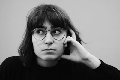 Close-up of thoughtful young woman against wall