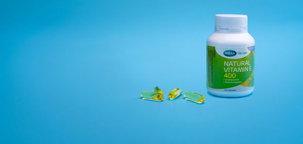 Close-up of green bottle against blue background