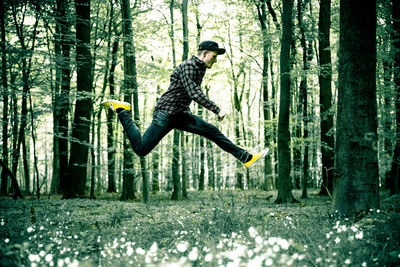 Side view of a man jumping in forest