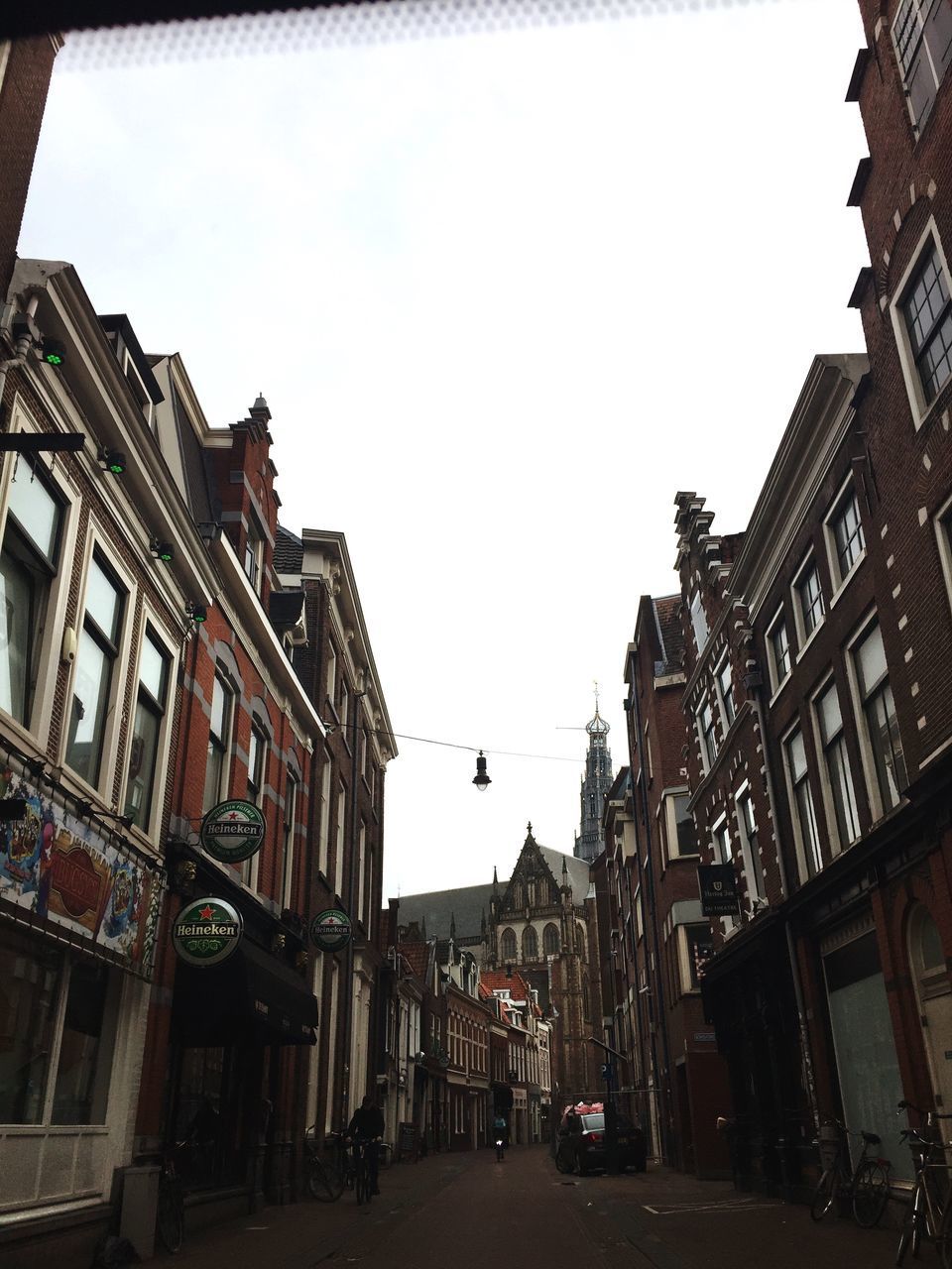 STREET AMIDST BUILDINGS IN CITY AGAINST SKY