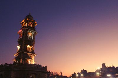 Low angle view of illuminated building against sky during sunset