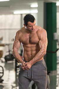 Shirtless man exercising in gym