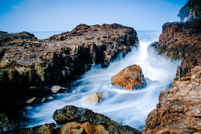 Scenic view of waterfall against sky