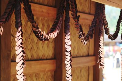 Close-up of tied hanging on rope against wall