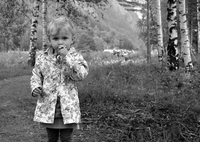 Portrait of girl holding flower in forest