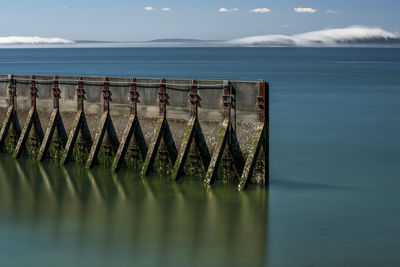 Scenic view of swimming pool by sea against sky