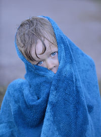 Portrait of boy wrapped in blue towel