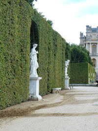 Statue against trees and building against sky