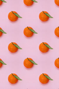 Mandarin oranges pattern on pink background. creative pattern, fruit background.