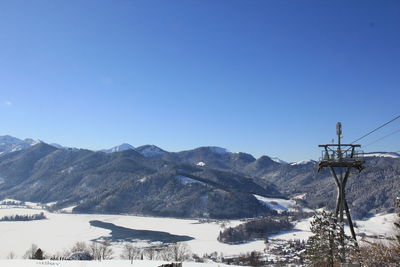 Scenic view of mountains against clear blue sky during winter