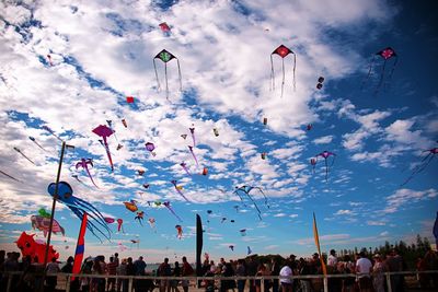 Kites flying over people against sky