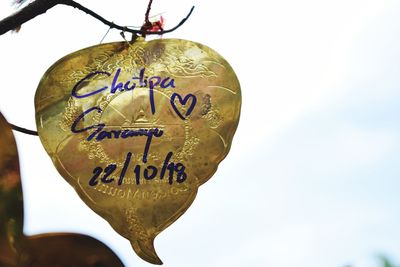 Close-up of heart shape hanging against sky