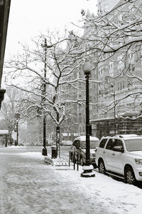 Man walking on snow covered street in city