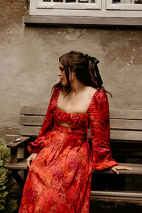 Young woman standing against wall