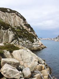 Rock formations by sea against sky