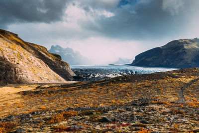 Scenic view of glacier and mountains against sky