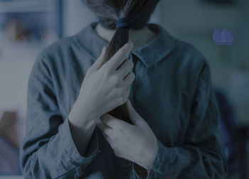 Woman covering face with ponytail